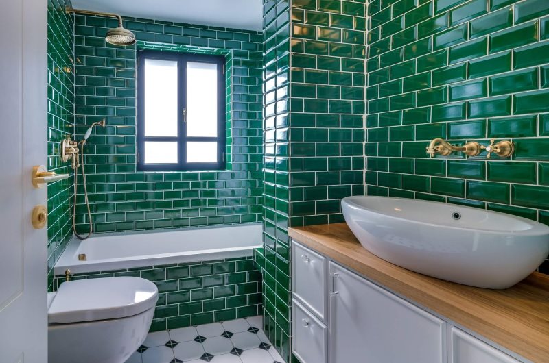 Плитка изумрудного цвета на стенах ванной с окном