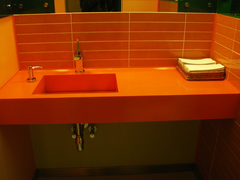 Оранжевая плитка над столешницей в ванной