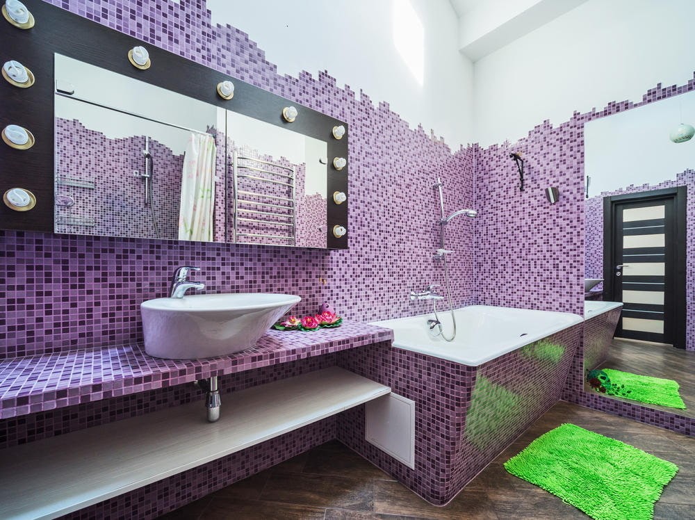 Зеленый коврик на полу ванной с мозаикой