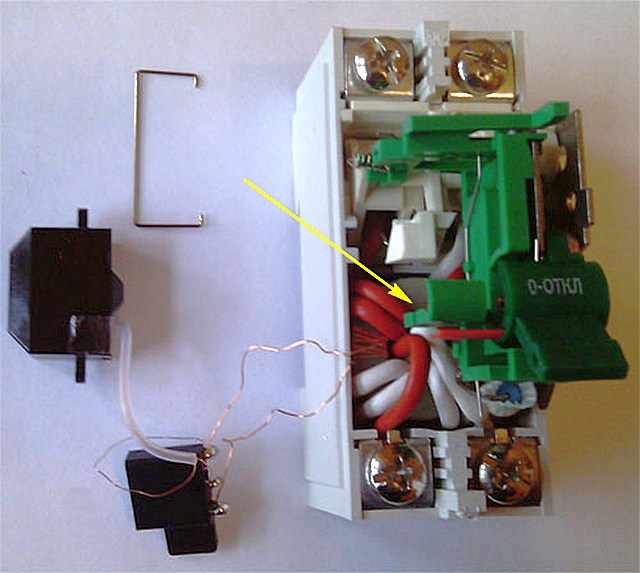 На иллюстрации стрелкой показан дифференциальный трансформатор с тороидальным сердечником и тремя обмотками.