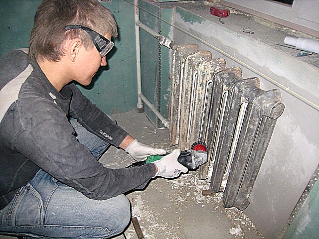 Очистка чугунных радиаторов с помощью металлической щетки-насадки, установленной на шлифмашинку. Работа грязная и утомительная, но, увы, без нее качество будет не то…  