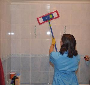 Женщина моет стены в ванной
