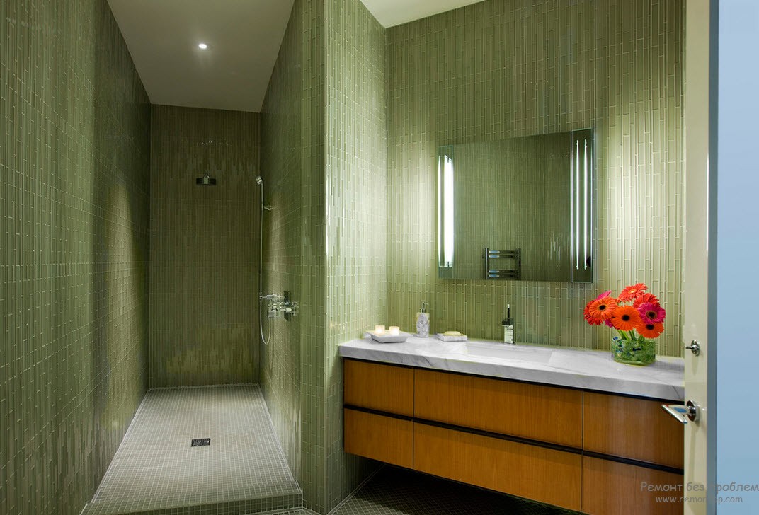 Стена ванной комнаты отделана мозаикой зеленого цвета